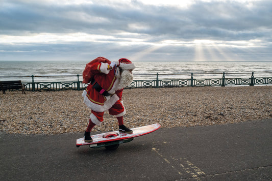 Santa riding a skateboard along Brighton seafront