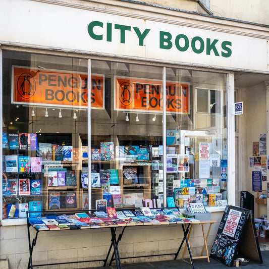 Exterior of City Books in Hove, an independent bookshop on Western Road with a book laden table outside and window displays filled with books.